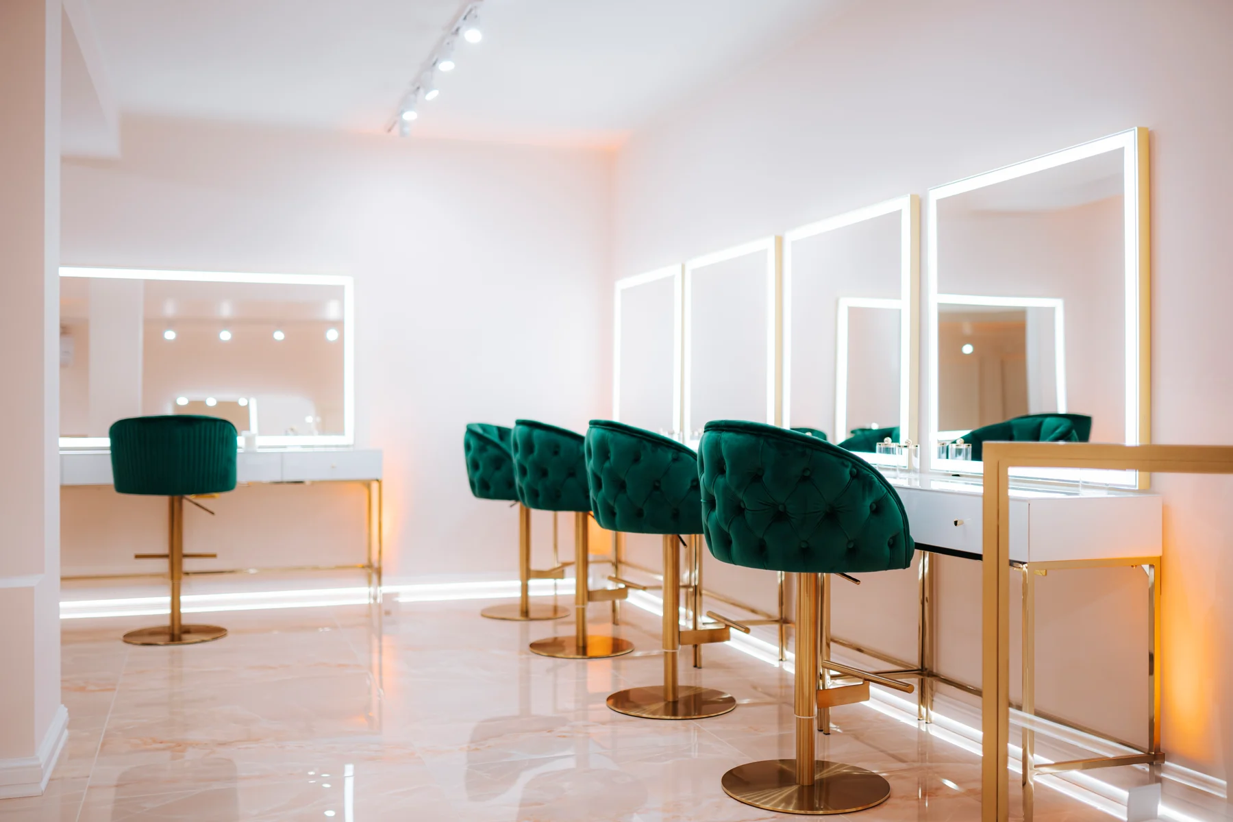 Le postazioni makeup dello studio, con specchi illuminati e poltrone verdi